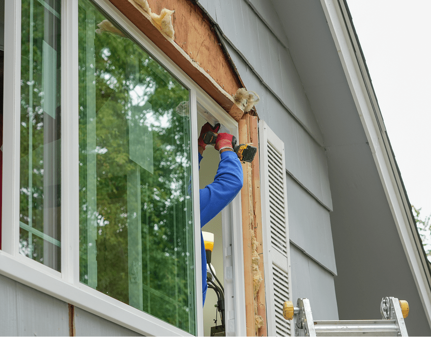 Worker replacing residential window frame